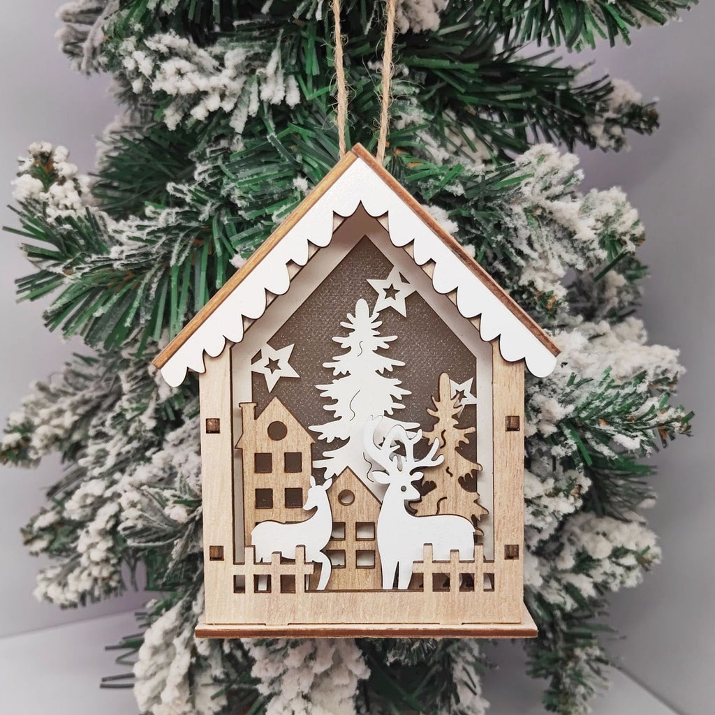 Illuminated wooden Christmas house as tree ornament