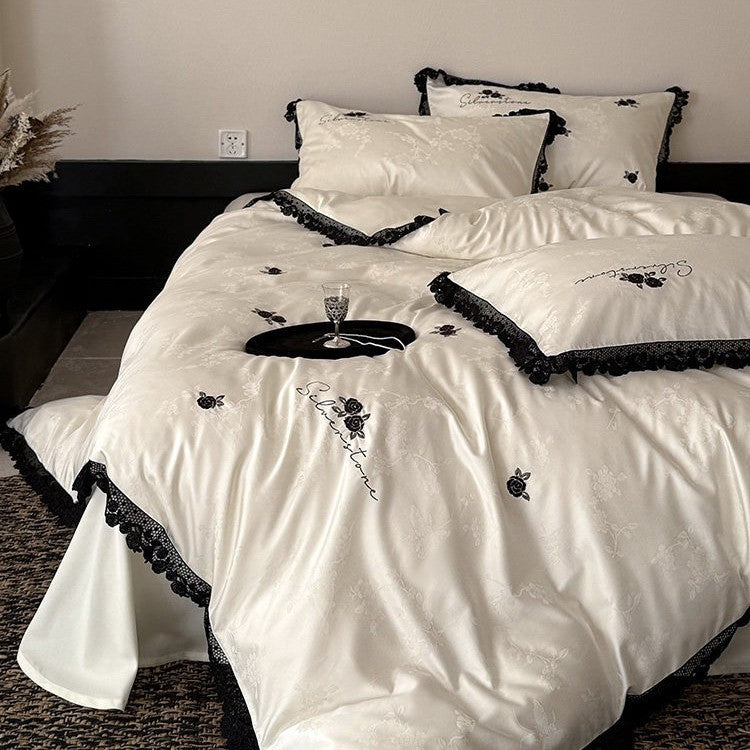 Luxurious satin bedding set with black lace trim and embroidered rose appliqués