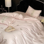 Luxurious satin bedding set with embroidered floral appliqués and bolster Bowlift