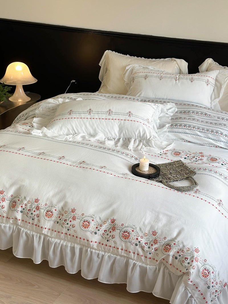 Lightly washed cotton bedding set with ruffled border and fine floral embroidery