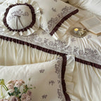 Luxurious bedding set with embroidered cover, ruffled bed skirt, and decorative pillow