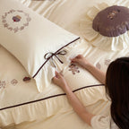Embroidered bedding set with ruffled trim, teddy design and decorative pillow