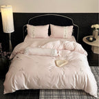 Luxurious satin bedding set with embroidered floral appliqués and bolster Bowlift