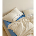 Cotton gauze bedding set with delicate border embroidery and mottled nep structure