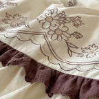 Luxurious bedding set with embroidered cover, ruffled bed skirt, and decorative pillow