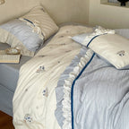 Romantic cotton satin bedding set with ruffles, embroidered flower bouquets, and decorative rolls Bowlift