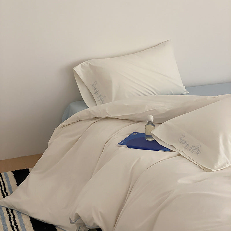 Cotton satin bed linen set with contrasting piping and subtle brand embroidery
