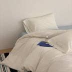 Cotton satin bed linen set with contrasting piping and subtle brand embroidery