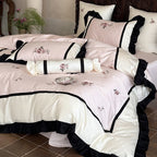 Luxurious embroidered bed linen set made of cotton satin with ruffles and decorative pillows