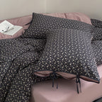 Reversible bedding set made of cotton satin with a fine floral allover, contrasted inside and decorative ribbons.
