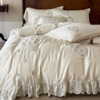 Satin bedding set with embroidered wreath motif, ruffled hem and decorative piping