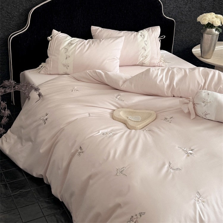 Luxurious satin bedding set with embroidered floral appliqués and bolster Bowlift