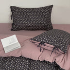 Reversible bedding set made of cotton satin with a fine floral allover, contrasted inside and decorative ribbons.