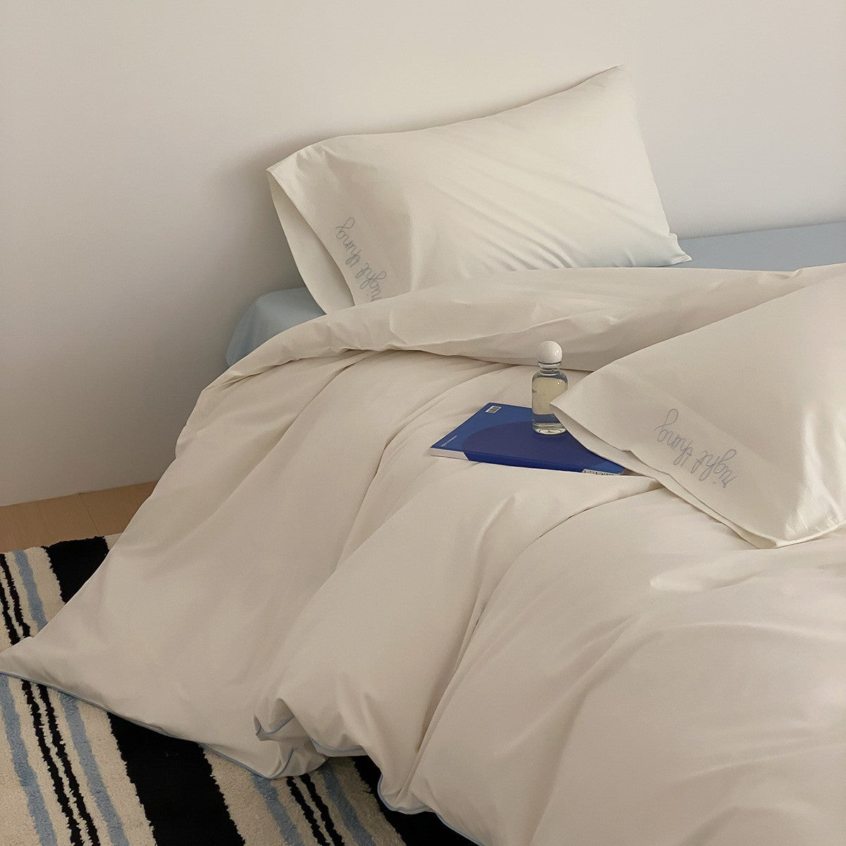 Cotton satin bed linen set with contrasting piping and subtle brand embroidery