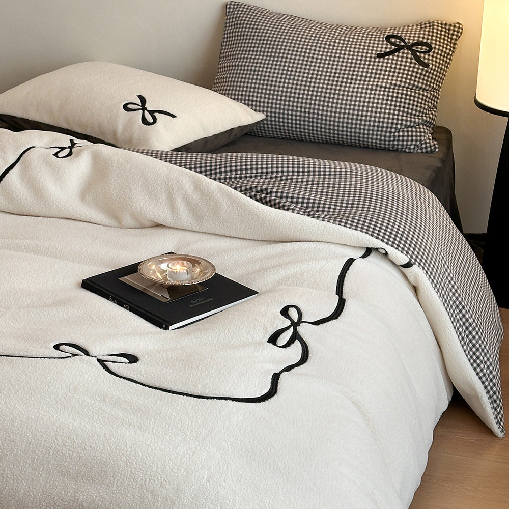 Reversible microfiber bedding set with plush surface, pom-pom corners, and paw embroidery
